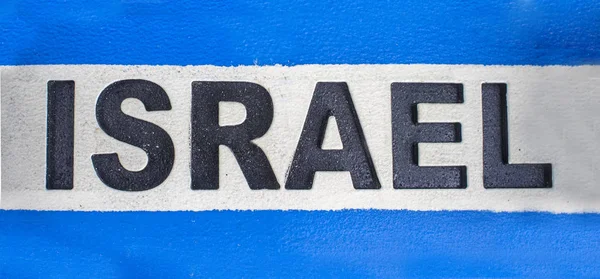 Sign with name of Israel in spanish and flag as background — Stock Photo, Image