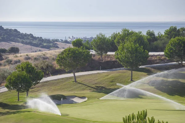 Система полива работает на зеленом поле для гольфа. Коста-дель-Соль, Спа — стоковое фото