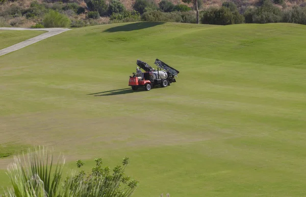 Sprayer machine performing maintenance at golf course. Shelf pro