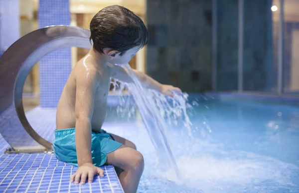 Kapalı havuz Spa'da jetlerle oynayan 4 yıllık çocuk — Stok fotoğraf