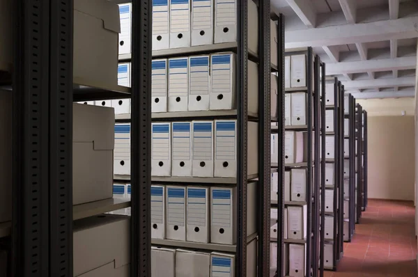 Historical archive warehouse full of carton boxes. Shelves perpective shot