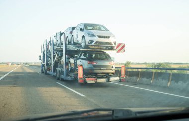 Otoyoldaki araba taşıyıcısı karavanı. Arabanın içerisinden bak.