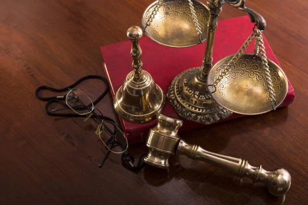 Bronze scales,gavel, bell, book and glasses on the table