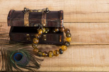 Doğal kehribar kolye, kutu ve tavus kuşu tüyü kurullarında