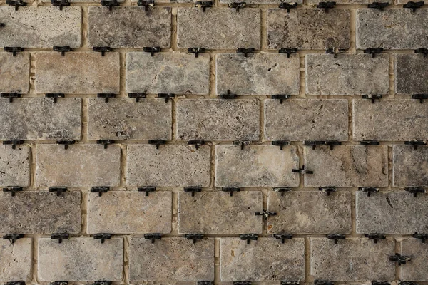 Tiles with crosses on the wall during the work of the tiler