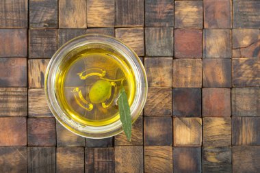 Antika ahşap mozaik arka planda yeşil yapraklı zeytin.