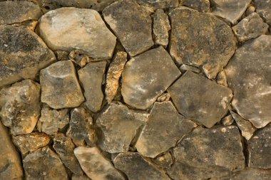 Doğal taşla kaplı antik bir duvarın parçası.