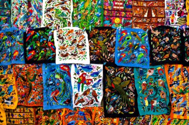 Geleneksel yerli nakış desenleri kuşların pazarda satılmak üzere farklı renkte ektikleri Antigua Guatemala.