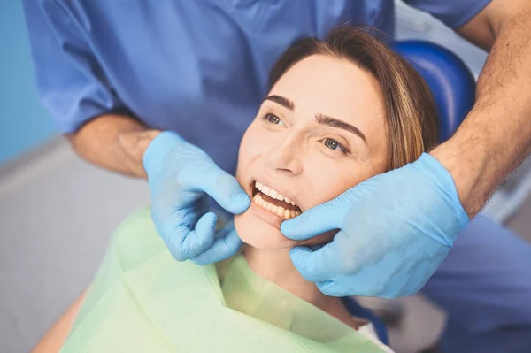 牙科医生在牙科诊所使用牙科设备检查病人的牙齿 口腔医学和保健概念 年轻英俊的男医生 戴着一次性医疗面罩 微笑着快乐的女人 — 图库照片