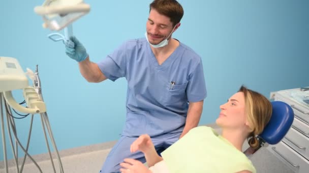 Dentista Muestra Paciente Los Resultados Del Tratamiento Con Espejo Examinando — Vídeo de stock