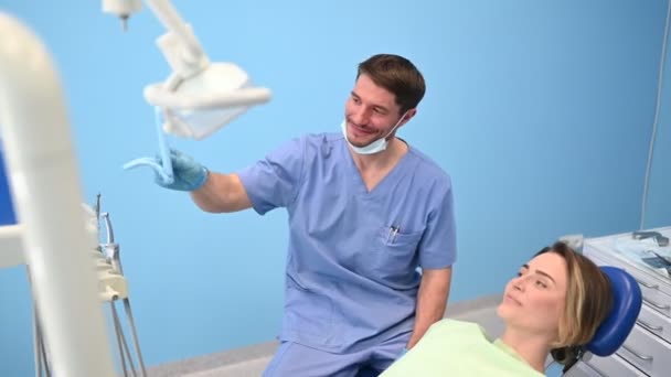 Dentista Muestra Paciente Los Resultados Del Tratamiento Con Espejo Examinando — Vídeo de stock