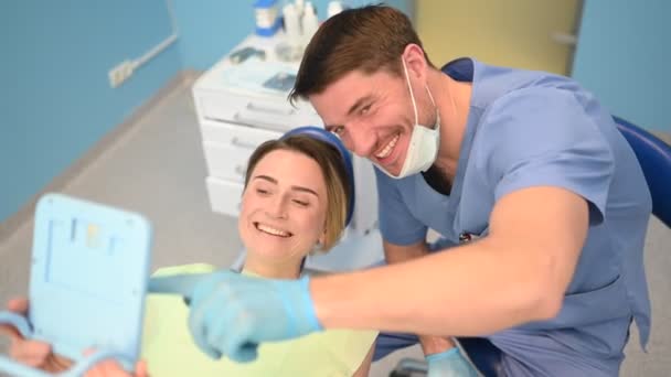 Dentista Muestra Paciente Los Resultados Del Tratamiento Con Espejo Examinando — Vídeo de stock