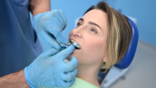 牙科医生在牙科诊所用牙科设备印模勺对病人的牙齿进行硅胶铸造 口腔医学和保健概念 戴医疗手套的医生 笑容满面的快乐女人 — 图库视频影像