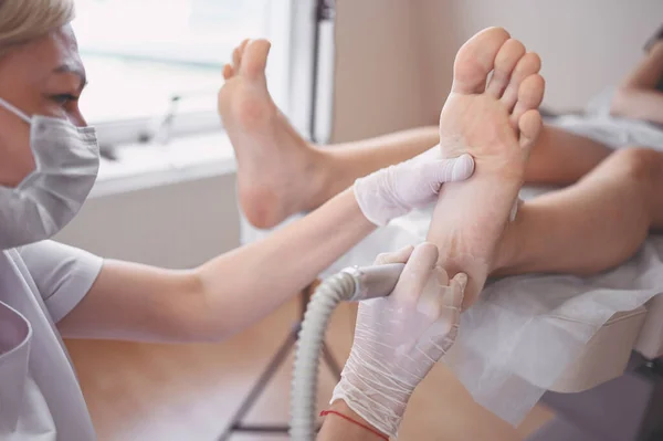 Podiatrist Lekarz Pomocą Sprzętu Szlifierskiego Czyniąc Zabieg Polerowania Stóp Pedicure — Zdjęcie stockowe