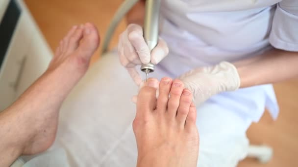 Sprzęt medyczny pedicure z aparaturą do wiercenia paznokci. Pacjent na pedicure z pediatrą, kręgarzem. Leczenie peelingu stóp w spa ze specjalnym urządzeniem. Klinika Podiatrii Podologia — Wideo stockowe