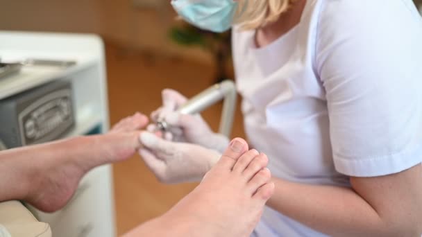 Hardwarová lékařská pedikúra s pilníkem na nehty. Pacient na pedikúře s dětským chiropodistou. Léčba peelingem nohou v lázních se speciálním zařízením. Klinika Podiatrie Podologie — Stock video