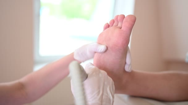 독 지학자는 가는 기구를 사용하고 구두약을 만들어 발에 윤활제를 만든다. 흰 장갑을 끼고 전문 도구로 고객의 다리 피부를 청소하는 검시 미용사. — 비디오