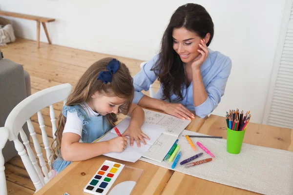 Mosolygó Anya Lánya Órákra Készülnek Ceruzákkal Festékekkel Rajzolnak Asztalhoz Szülő — Stock Fotó