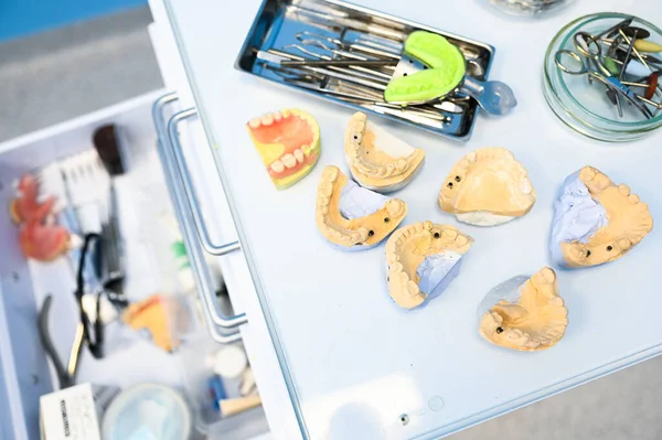 Different professional dental equipment, instruments and tools in a dentists stomatology office clinic on a white background. Silicone cast of the jaw