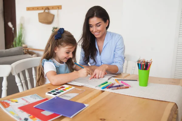 Усміхнена Мати Дочка Готуються Уроків Малюють Столом Олівцями Фарбами Батько — стокове фото