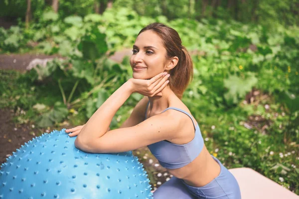 肌肉纤细迷人的女性 扁平的腹部完美的身体 美丽的年轻适合做瑜伽练习的女子与健身普拉提蓝色球在夏季公园室外 运动的生活理念 — 图库照片