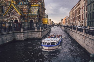 Aziz Petrus Burgusu, Rusya - 21 Ağustos 2020. Griboyedov Kanalı boyunca turistlerin gezdiği bir gezi teknesi akşam üzeri dökülen kanla Kurtarıcı Kilisesi 'nin önünden geçiyor.. 