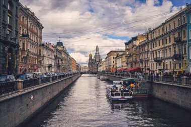 Saint Petersburg, Rusya - Ağustos 2020. Griboyedov Kanalı boyunca turistlerin gezdiği bir gezi teknesi akşam üzeri dökülen kanla Kurtarıcı Kilisesi 'nin önünden geçiyor.. 
