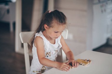 Anaokulunda masa başında otururken tahta matematiksel çok renkli figürlerle eğitici oyunlar oynayan küçük tatlı anaokulu çocuğu. Okul konseptine dönelim.