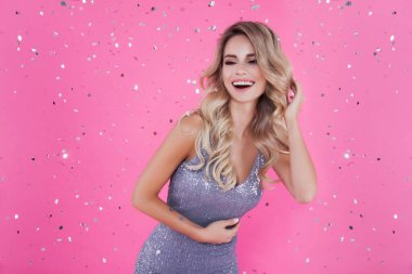 Gümüş renkli, ışıltılı elbiseli, harika bir sarışın, gülümseyen bayan, büyük etkinliğe, konsere, satışa, indirimli mesaja, konfetiye dikkat çekiyor. Metin için boş alan