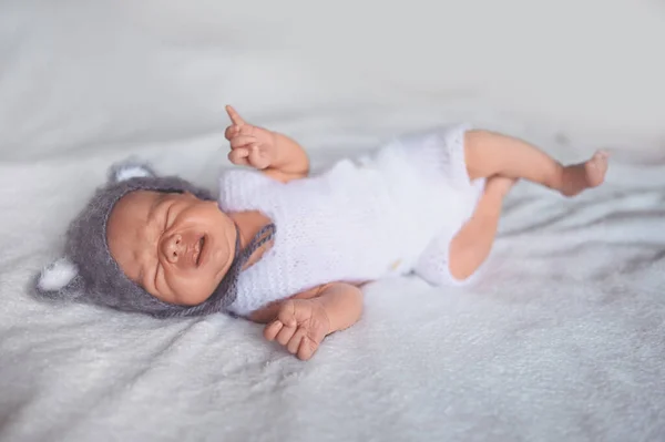 Mignon petit garçon pleurant nouveau-né dormant dans un berceau en costume tricoté avec des oreilles. Modèle d'emballage de marchandises pour bébés. Enfant en santé, concept d'hôpital et de maternité heureuse. Bébé bébé. Pépinière — Photo