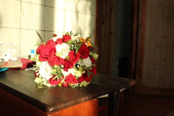 white red bouquet with red roses on the table