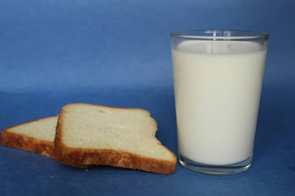 Toastbrot Und Ein Glas Milch Auf Blauem Hintergrund — Stockfoto