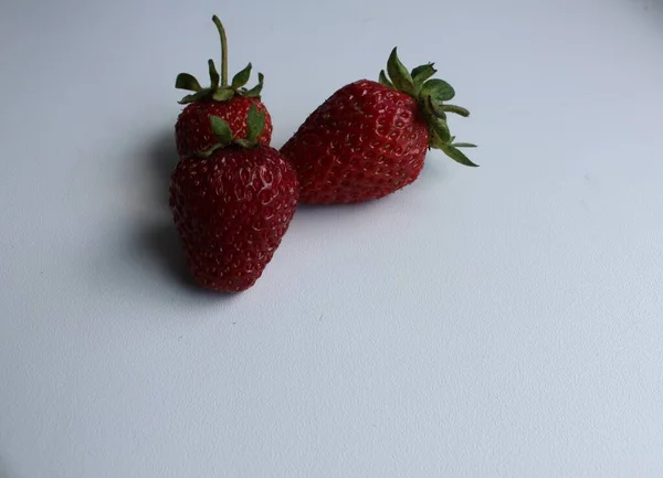 两三个红色成熟草莓在一个白色的背景复制空间上 — 图库照片