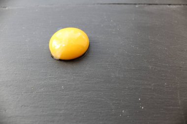 Bir yumurta sarısı ya da kayısı şeftalisinin yarısı gri taştan siyah bir arka planda mesaj eklemek için bir yer var.