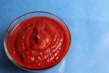 Mavi arka planda cam bir tencerede kırmızı domates sosu ve metin mutfağı kafe restoranı için yer.