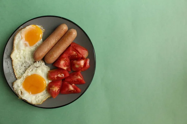 Cibo Colazione Piatto Grigio Sfondo Verde Salsicce Pomodori Uova Strapazzate — Foto Stock