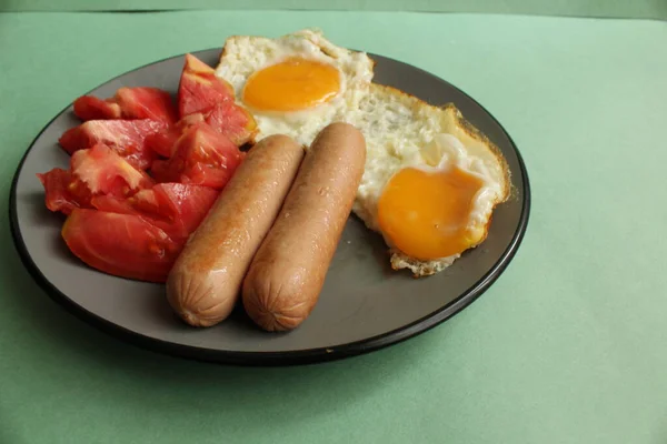 Frukost Mat Grå Platta Grön Bakgrund Korv Tomater Äggröra Stekta — Stockfoto