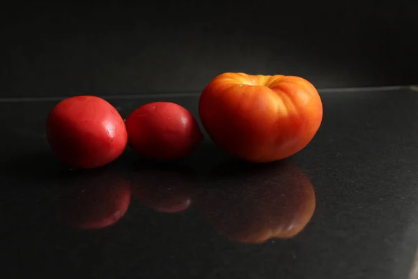 Três Tomates Vermelhos Amarelos Jazem Fundo Preto Vista Lateral Comida — Fotografia de Stock