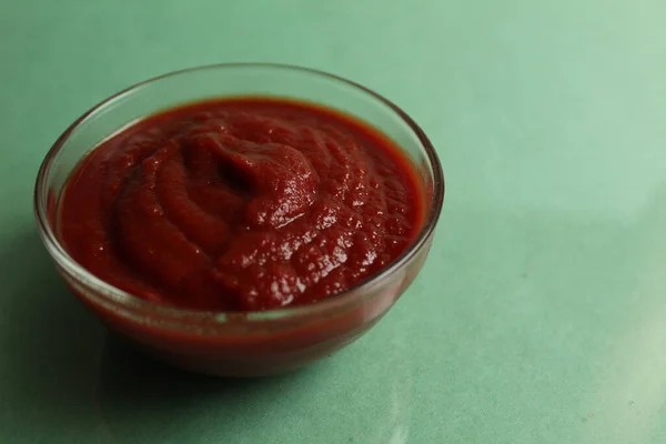 Salsa Pomodoro Rosso Una Ciotola Vetro Pentola Uno Sfondo Verde — Foto Stock