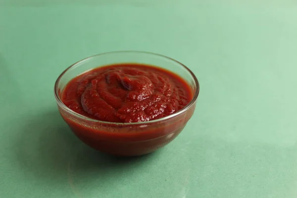 Salsa Pomodoro Rosso Una Ciotola Vetro Pentola Uno Sfondo Verde — Foto Stock