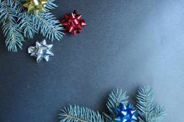 Yılbaşı arkaplanının çam ağacı dalları ve siyah gri arka planda Noel yayları