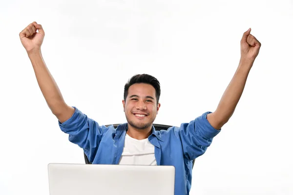 穿着便装的初创企业男子举起双手为在使用笔记本电脑时实现工作感到高兴 — 图库照片