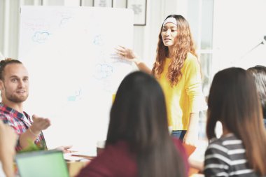 Genç Asyalı işkadını gelecekteki planları ofiste iş arkadaşları için sunu yapma