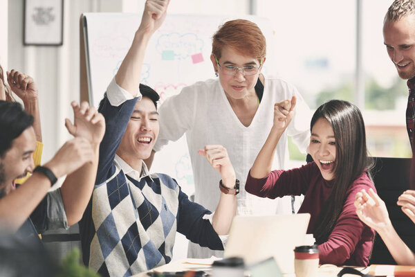 Group of businesspersons feeling happy and cheering successful work on screen