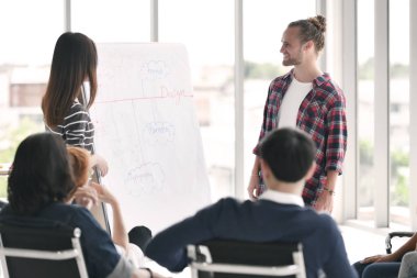 Tartışıyor ve sunma genç iş adamlarını ofiste iş arkadaşları grup için çalışmak