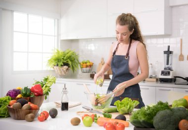 Genç kadında sağlıklı sağlıklı yemek ve salata sebze hazırlama bir mutfak