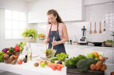 Genç kadında sağlıklı sağlıklı yemek ve salata sebze hazırlama bir mutfak