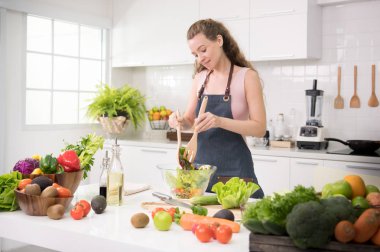 Genç kadında sağlıklı sağlıklı yemek ve salata sebze hazırlama bir mutfak