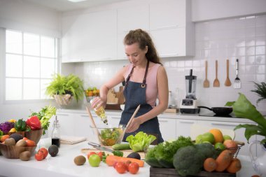 Genç kadında sağlıklı sağlıklı yemek ve salata sebze hazırlama bir mutfak