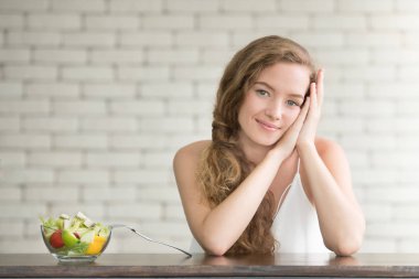 Yanında salata kasesi ile neşeli duruşlar güzel genç kadın